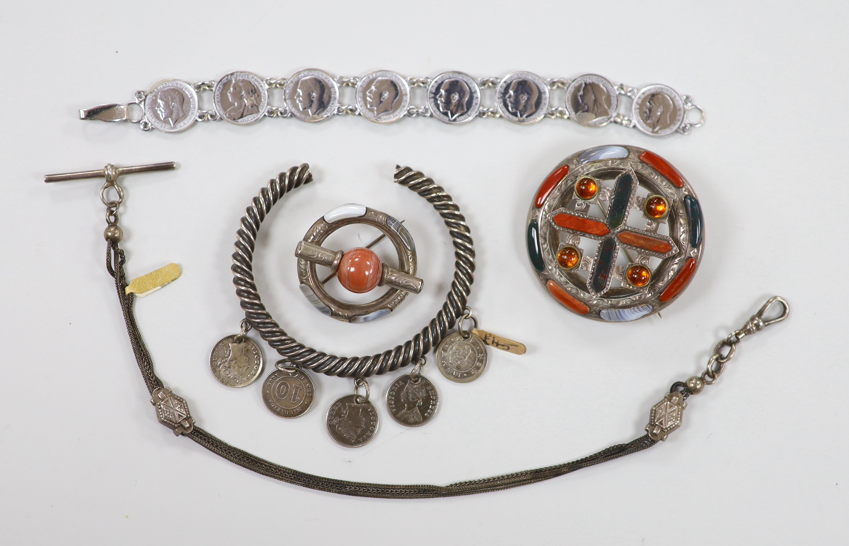 Two white metal and Scottish hardstone set brooches, largest 51mm, two coin set bracelet and a fob chain.